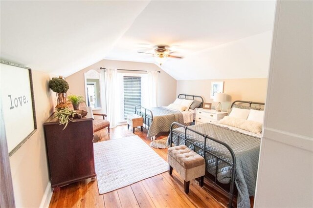 bedroom with ceiling fan, lofted ceiling, and light wood-type flooring