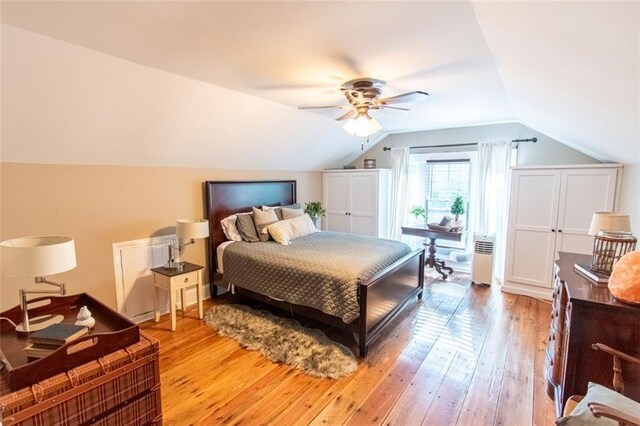 bedroom featuring light hardwood / wood-style floors, vaulted ceiling, and ceiling fan