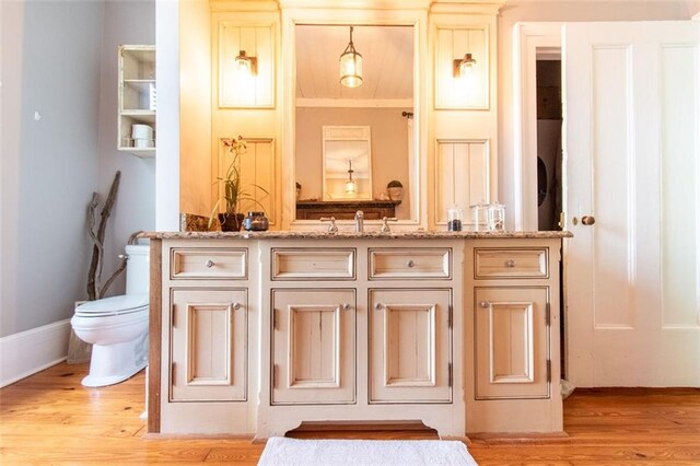 bathroom with ornamental molding, vanity, toilet, and hardwood / wood-style flooring