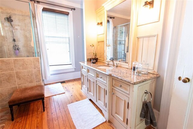 bathroom featuring walk in shower, wood-type flooring, vanity, and a wealth of natural light