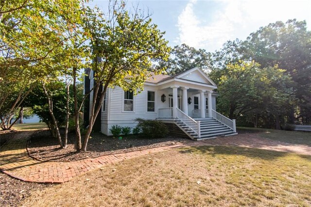 greek revival house featuring a front yard and a porch