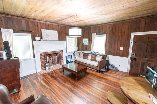 living room featuring wooden ceiling, wooden walls, dark wood-type flooring, and a brick fireplace