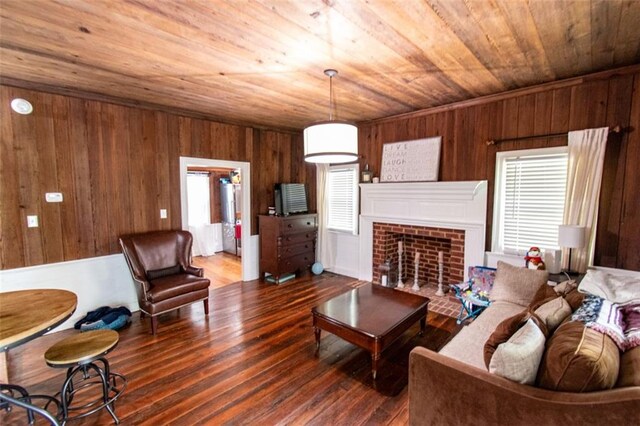 living room featuring a brick fireplace, wood ceiling, wood walls, and dark hardwood / wood-style flooring