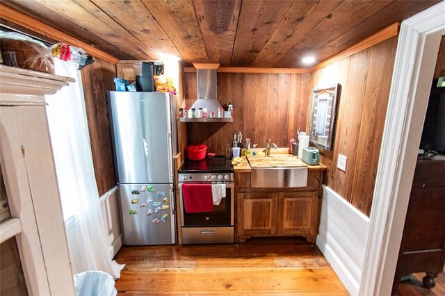 kitchen featuring wood ceiling, stainless steel appliances, light hardwood / wood-style flooring, sink, and wall chimney range hood