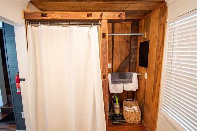 bathroom featuring wood walls and electric panel