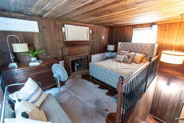 bedroom with wooden walls, a fireplace, and wood ceiling