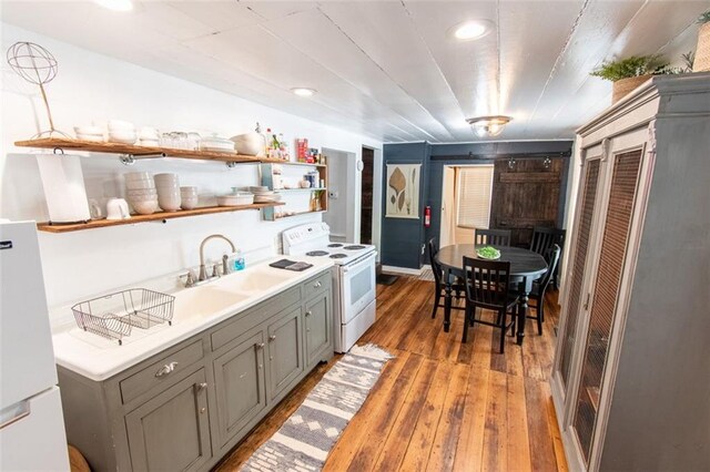 kitchen featuring gray cabinetry, white appliances, sink, and wood-type flooring