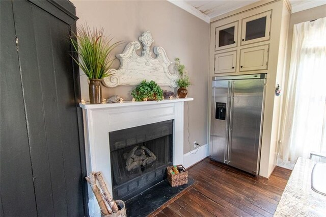 kitchen featuring crown molding, cream cabinets, dark hardwood / wood-style floors, and stainless steel fridge with ice dispenser