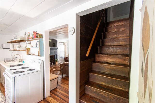 staircase featuring sink and hardwood / wood-style flooring