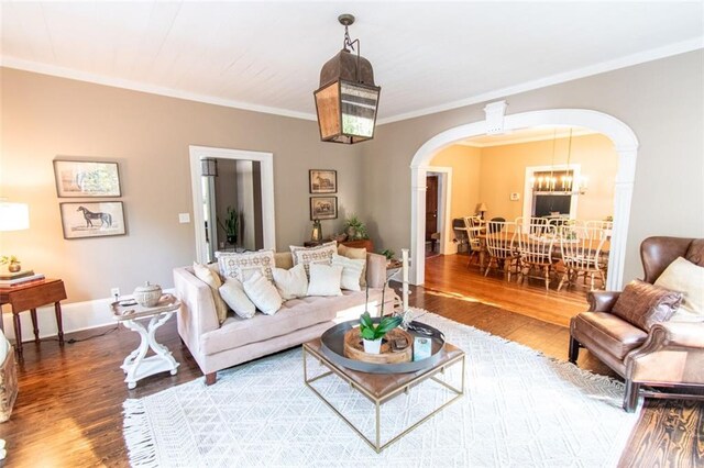 living room featuring hardwood / wood-style flooring, crown molding, and a chandelier