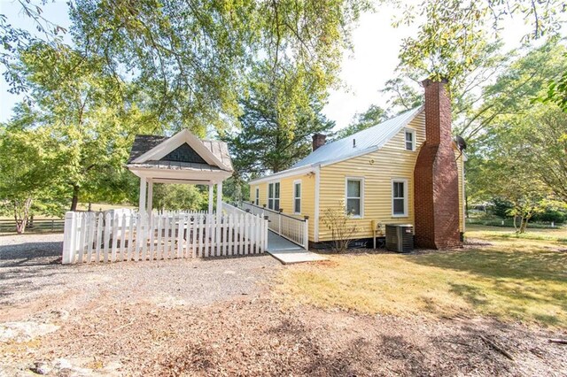 rear view of house featuring central AC unit and a deck