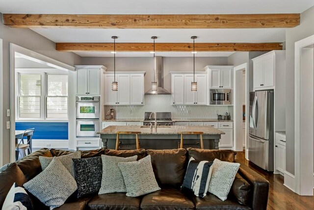 970 N Ormewood Park Dr SE, Atlanta, GA 30316 - kitchen featuring appliances with stainless steel finishes, wall chimney exhaust hood, open floor plan, tasteful backsplash, and white cabinets