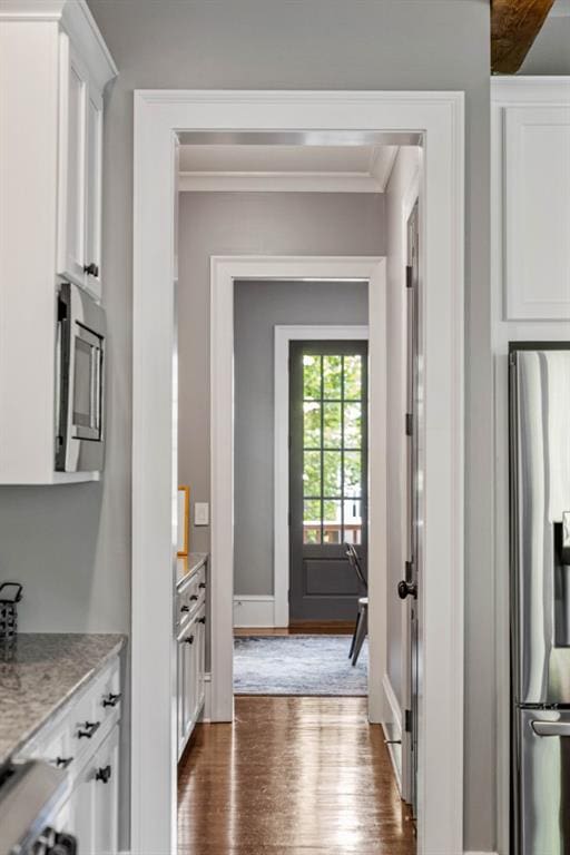 970 N Ormewood Park Dr SE, Atlanta, GA 30316 - kitchen featuring appliances with stainless steel finishes, dark wood-style floors, white cabinets, crown molding, and light stone countertops