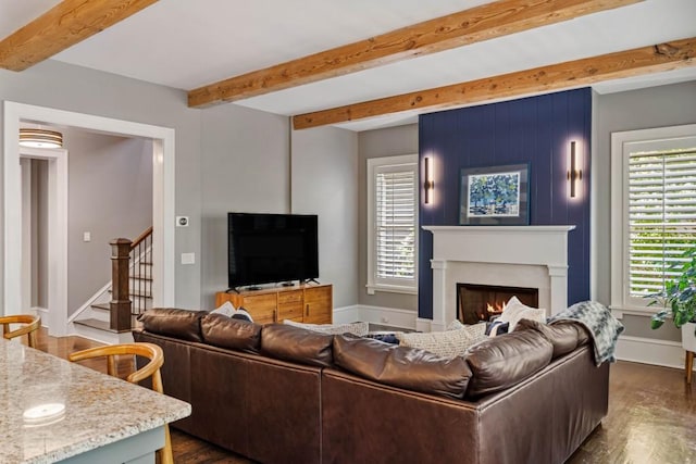 970 N Ormewood Park Dr SE, Atlanta, GA 30316 - living area with stairway, plenty of natural light, beam ceiling, dark wood-style floors, and a warm lit fireplace