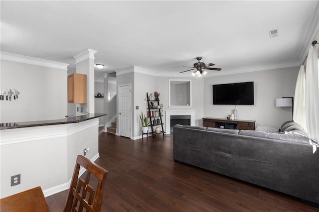 living room with crown molding, ceiling fan, and dark hardwood / wood-style flooring