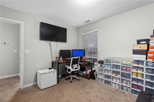 carpeted home office featuring a textured ceiling