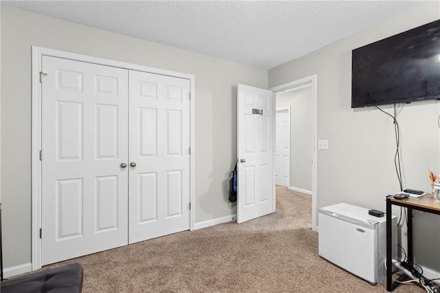 carpeted bedroom with a closet and a textured ceiling