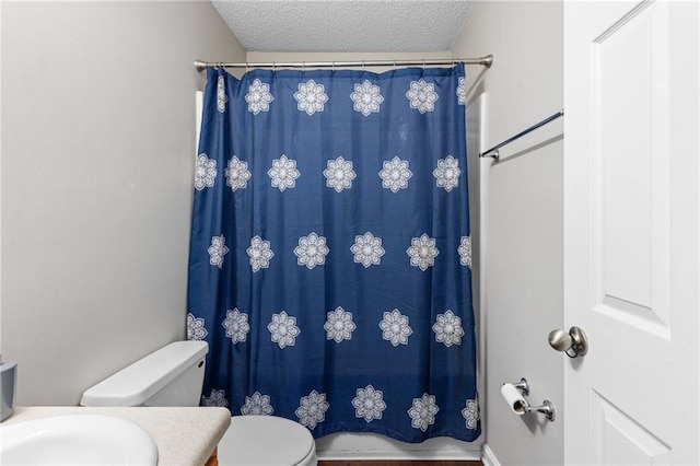 bathroom featuring walk in shower, toilet, and a textured ceiling