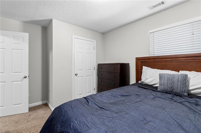 bedroom with carpet and a textured ceiling