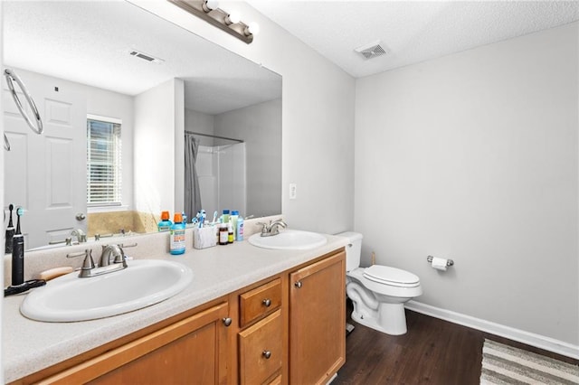 bathroom with wood-type flooring, vanity, toilet, a textured ceiling, and a shower with shower curtain