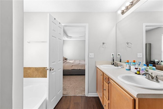 bathroom featuring hardwood / wood-style flooring, vanity, and a bath