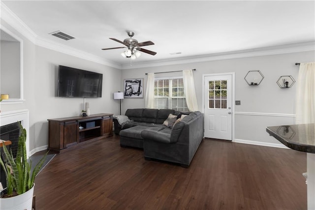 living room featuring dark wood-type flooring, ceiling fan, and ornamental molding