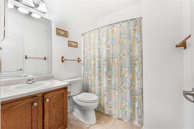 bathroom featuring tile patterned flooring, vanity, curtained shower, and toilet