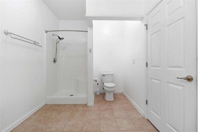 bathroom featuring tile patterned flooring, a shower, and toilet