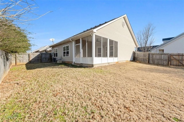 rear view of house with a yard and a sunroom