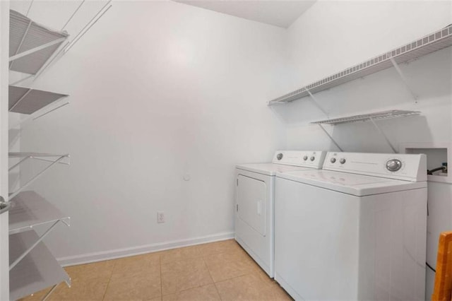 clothes washing area featuring light tile patterned flooring and washing machine and dryer