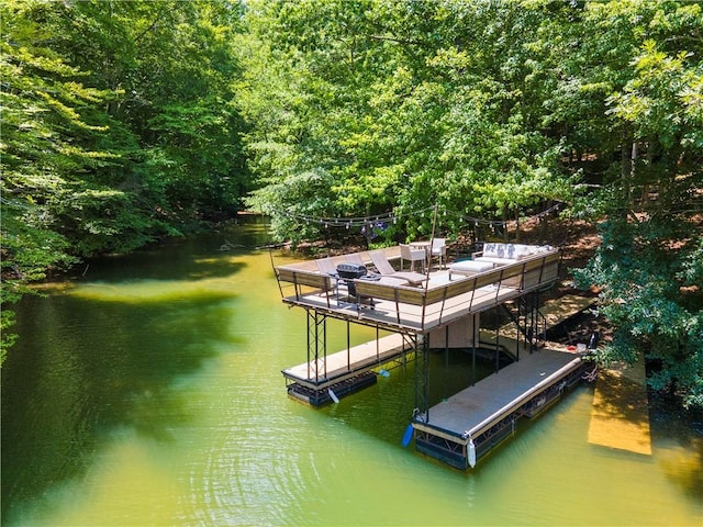 dock area featuring a wooded view and a water view