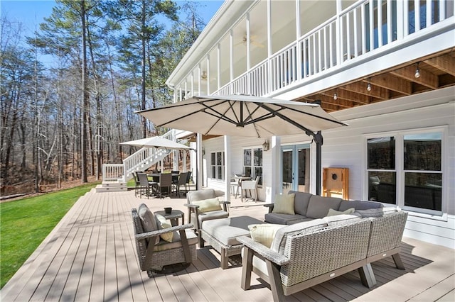 rear view of house with a patio, a lawn, a balcony, and stairs