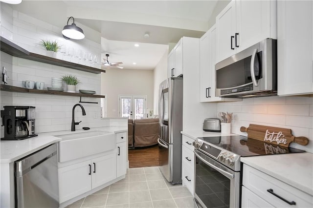 kitchen with tasteful backsplash, breakfast area, appliances with stainless steel finishes, white cabinets, and light countertops