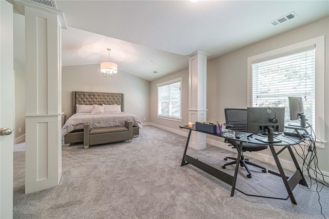 bedroom with light colored carpet, lofted ceiling, and ornate columns