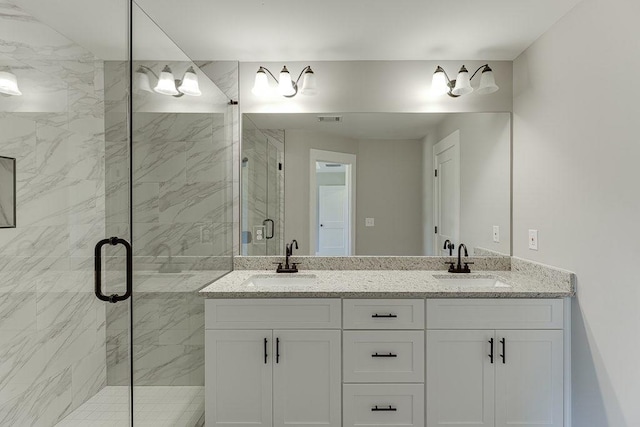 bathroom featuring double vanity, a stall shower, a sink, and visible vents