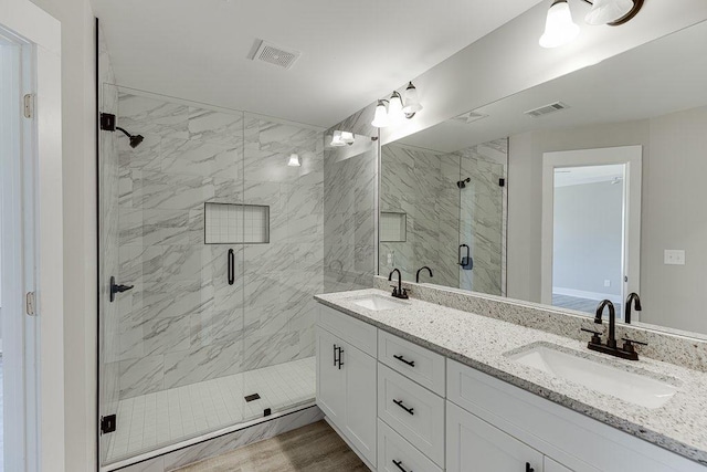 full bathroom featuring a stall shower, a sink, and visible vents