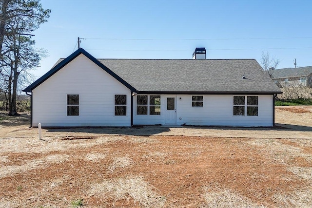 view of front of property with a shingled roof and a chimney