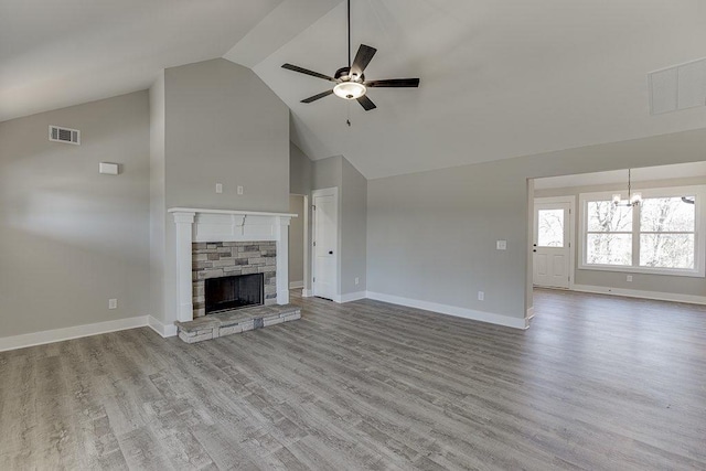 unfurnished living room featuring visible vents, a stone fireplace, baseboards, and wood finished floors