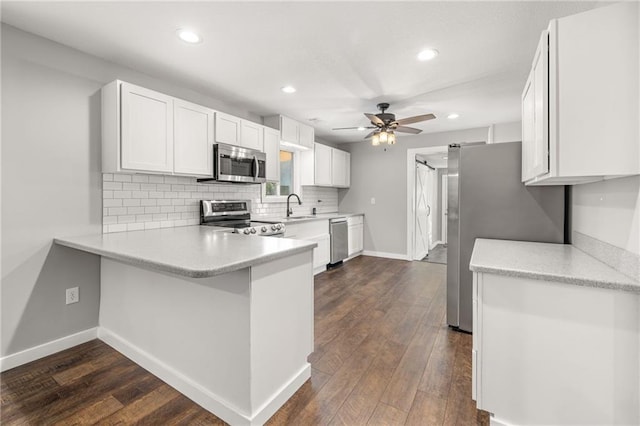 kitchen with white cabinets, sink, ceiling fan, appliances with stainless steel finishes, and kitchen peninsula