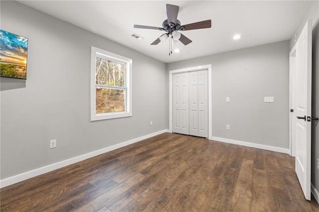 unfurnished bedroom featuring dark hardwood / wood-style flooring, a closet, and ceiling fan