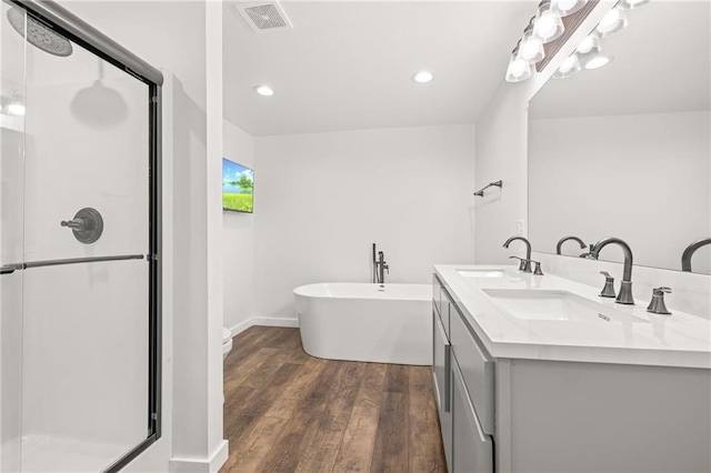 bathroom with plus walk in shower, wood-type flooring, and vanity