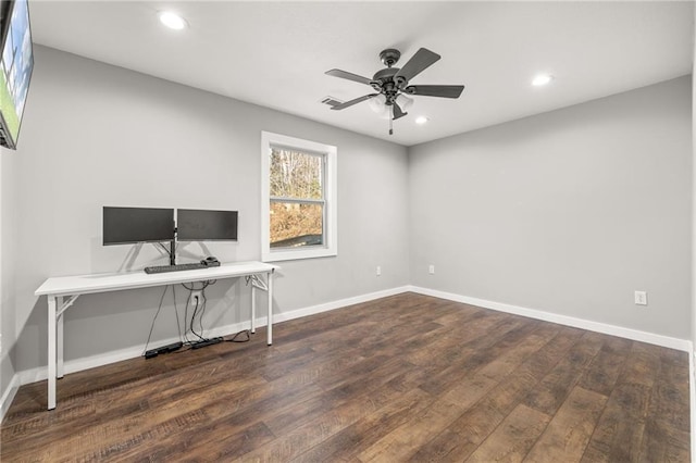 unfurnished office with ceiling fan and dark wood-type flooring