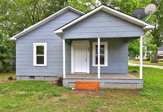bungalow-style home with covered porch, crawl space, and a front lawn