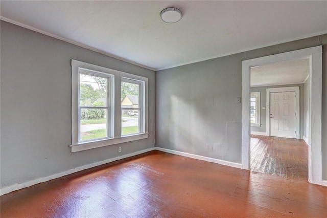 unfurnished room with wood finished floors, baseboards, and ornamental molding