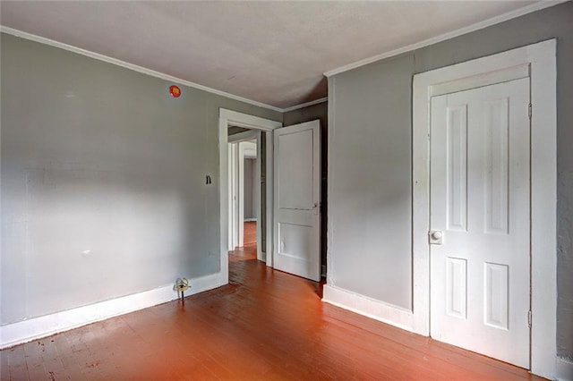 unfurnished bedroom with wood finished floors, crown molding, and baseboards