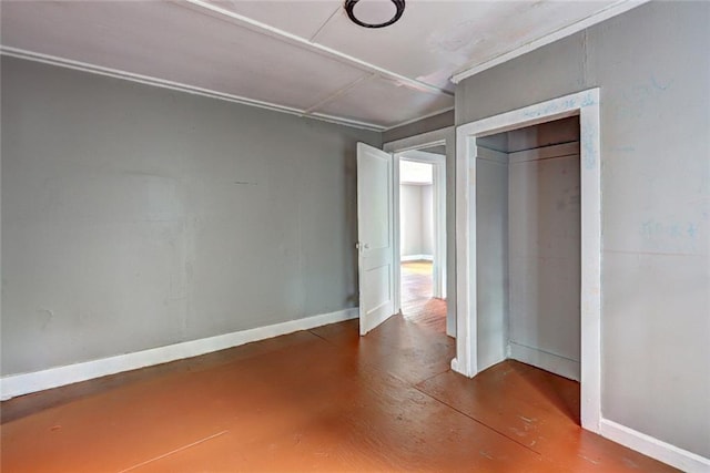 unfurnished bedroom featuring a closet, baseboards, and concrete flooring