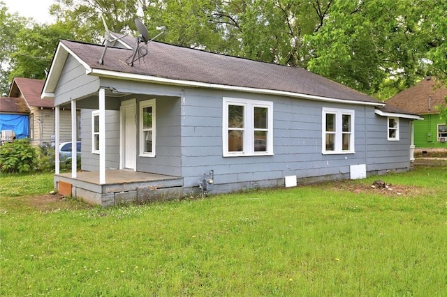 view of home's exterior with a lawn, roof with shingles, and a porch