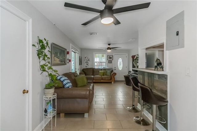 living room featuring tile patterned flooring, ceiling fan, and electric panel