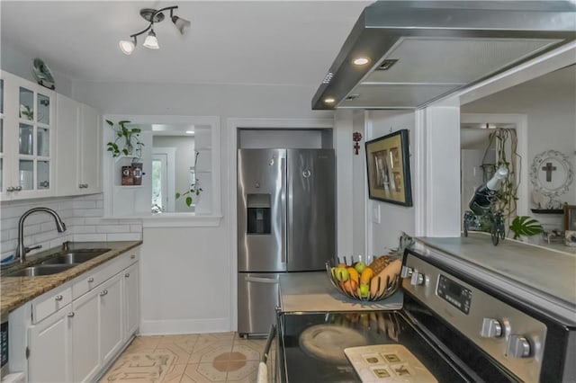 kitchen featuring appliances with stainless steel finishes, tasteful backsplash, wall chimney range hood, sink, and white cabinetry