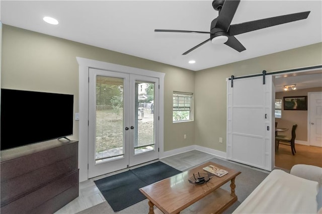 living room featuring french doors, a barn door, and ceiling fan